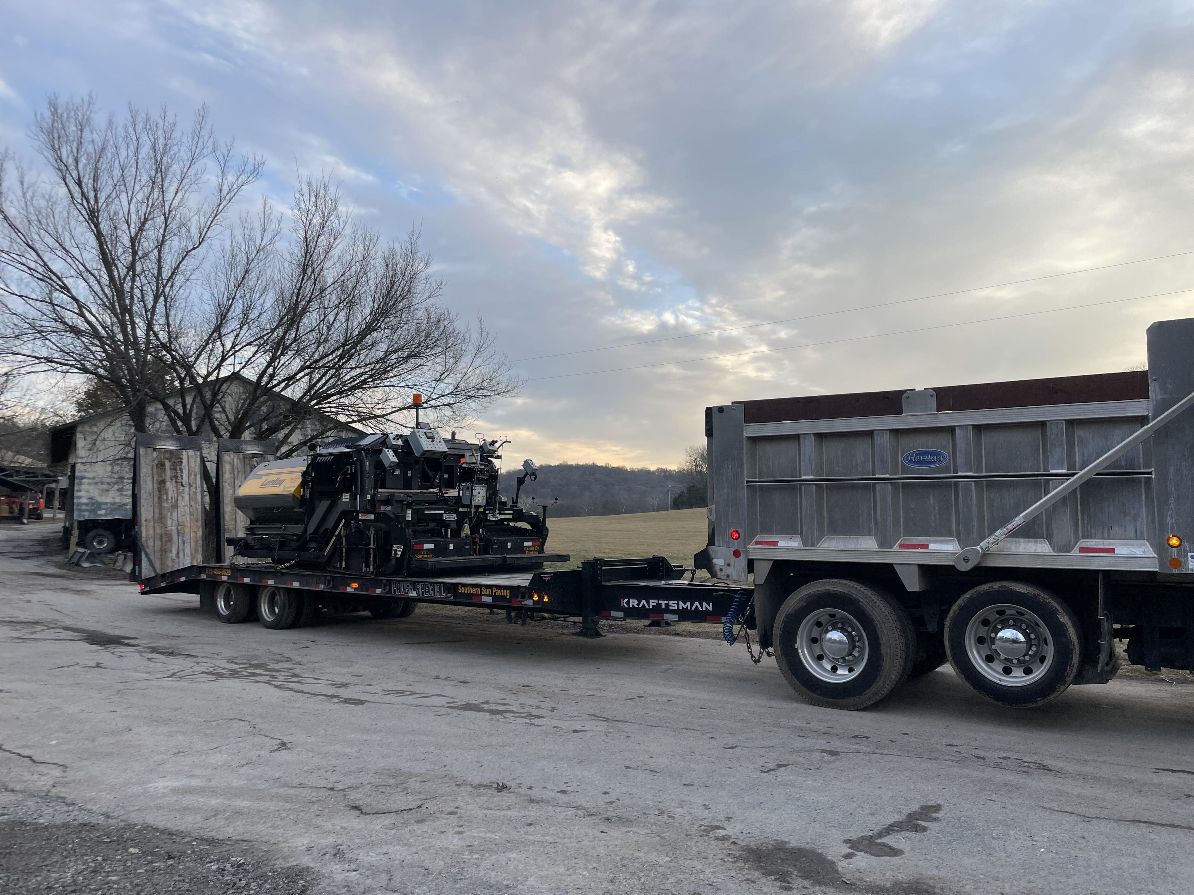gray dump truck pulling black kraftsman trailer